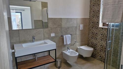 a bathroom with a sink and a toilet at Masseria Coccolo in Carovigno