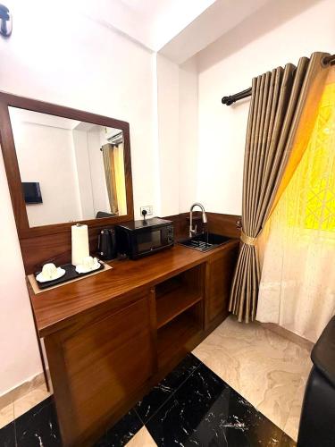 a bathroom with a vanity with a sink and a mirror at Downtown Virgins Hotel in Elmina
