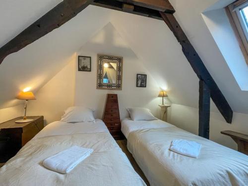 two beds in a room with a attic at Poutres et charme in Paimpol