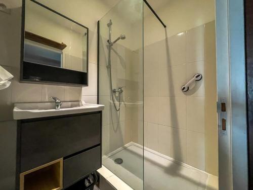 a bathroom with a shower and a sink and a glass shower backdoor at Poutres et charme in Paimpol