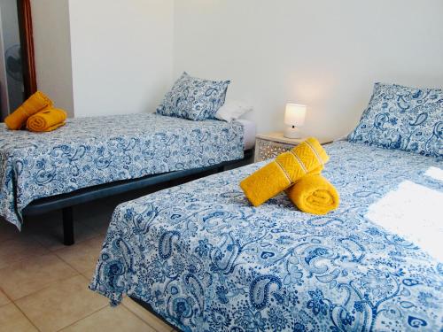 a bedroom with two beds with yellow towels on them at Casita Playa Castillo 5 in Caleta De Fuste