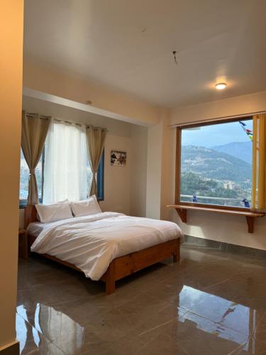a bedroom with a large bed and a large window at E-RE House, Dirang in Dirang Dzong