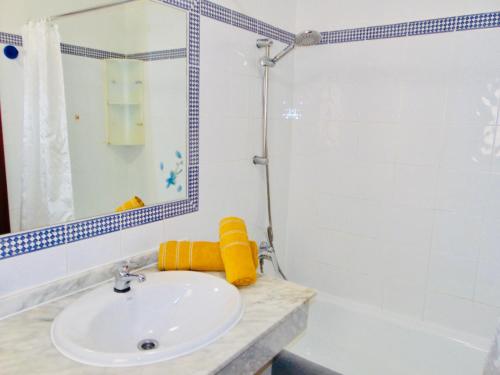 a bathroom with a sink and a tub and a mirror at Casita Playa Castillo 5 in Caleta De Fuste