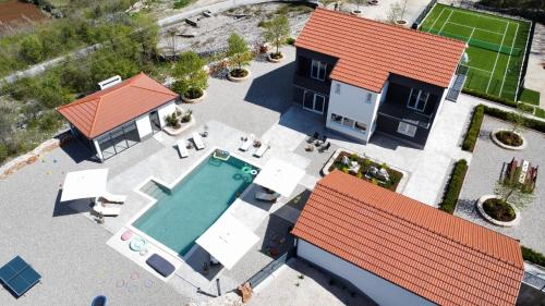 an overhead view of a house with a swimming pool at Vila Agape with a pool, football and tennis court in Lovreć