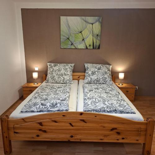 a bedroom with a wooden bed with two pillows at Gästehaus Sibylle in Rust