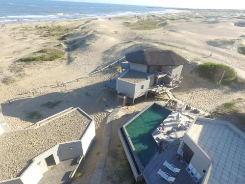 an aerial view of a house on the beach at MarAdentro Apart Hotel & Suites in Punta Del Diablo