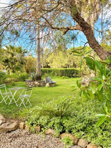 a park with two chairs and a bench in the grass at Glamping with Yoga and Natural Pool near Fuseta Beach in Moncarapacho