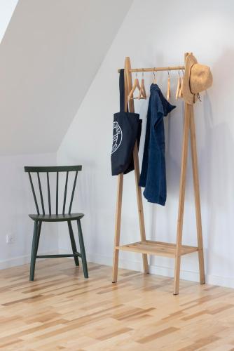 a wooden rack with a bag and a chair at Lønstrup Apartments, Havtorn in Lønstrup
