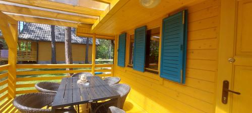 a wooden table and chairs on the porch of a cabin at Nartówka in Narty