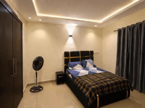 a bedroom with a bed and a light on the ceiling at Adesta Suites in Ilorin