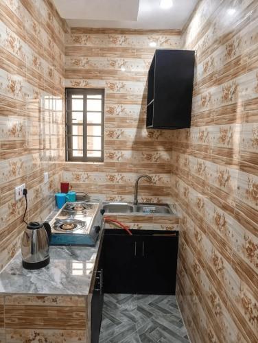 a kitchen with a sink and a stove at Adesta Suites in Ilorin