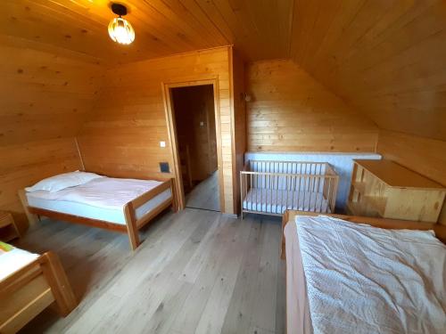 a room with two beds in a wooden cabin at Domek w górach Lachowice in Lachowice