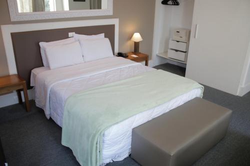 Un dormitorio con una cama grande con un edredón blanco. en Continental Porto Alegre by Samba, en Porto Alegre