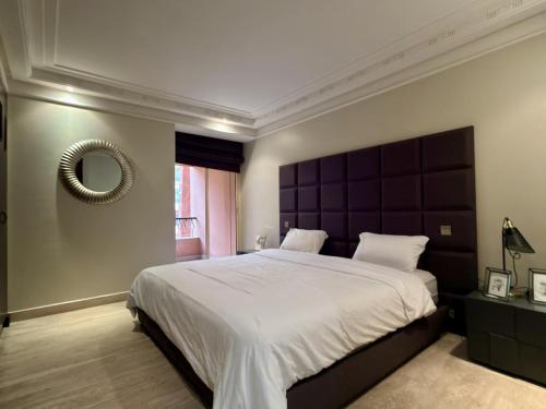 a large bedroom with a large bed and a mirror at Residence jardin ocre in Marrakesh