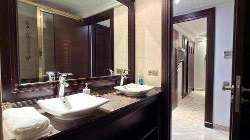 a bathroom with two sinks and a large mirror at Residence jardin ocre in Marrakesh