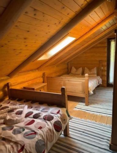 a bedroom with a bed in a wooden cabin at Cabanele 2 Mitici in Săliştea de Sus