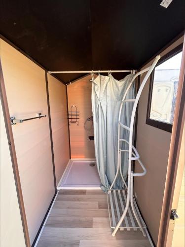 a shower in a small room with a shower curtain at Gite Esprit Etape in Saint-Barthélemy-de-Vals