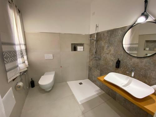 a bathroom with a sink and a toilet and a mirror at Hotel Villa Canu in Càbras
