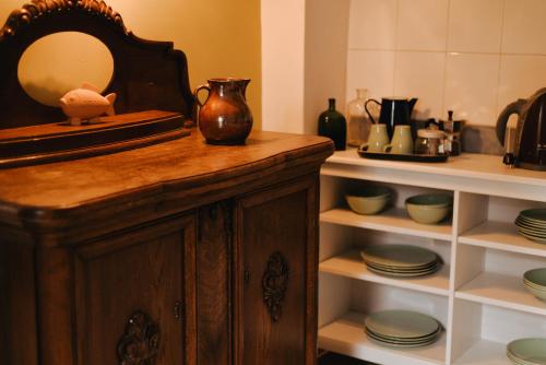 a mirror on top of a wooden cabinet with dishes at Domek gdzie śpią żurawie in Szymbark
