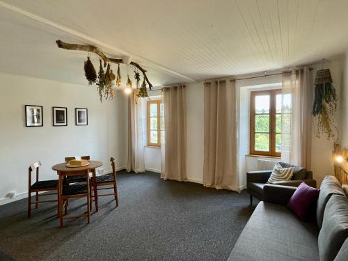 a living room with a table and a couch at LAne Têtu in Désaignes