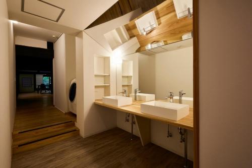 a bathroom with two sinks and a mirror at YADO SEN -仙- Komatsu in Komatsu