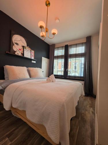 a bedroom with a large bed with a black wall at Tip &Top Deluxe Appartement in Vlissingen