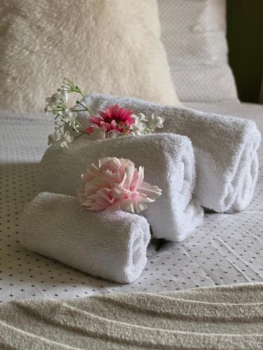 a pile of towels with flowers on a bed at Tip &Top Deluxe Appartement in Vlissingen