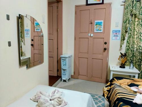 a room with a bed and a mirror and a door at Camigs Vacation House in Mambajao