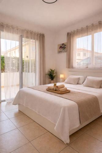 a bedroom with a large white bed with towels on it at Amigos Apartment Mythical in Protaras