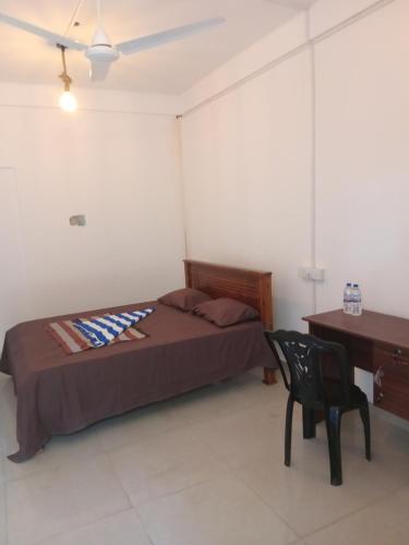 a bedroom with a bed and a desk and a chair at Amaya Hotel and Restaurant in Batigama