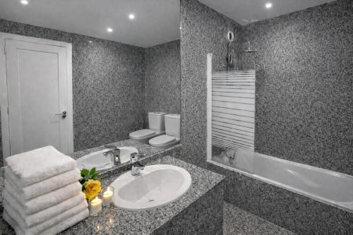a bathroom with a sink and a bath tub at City World Apartment in Maia