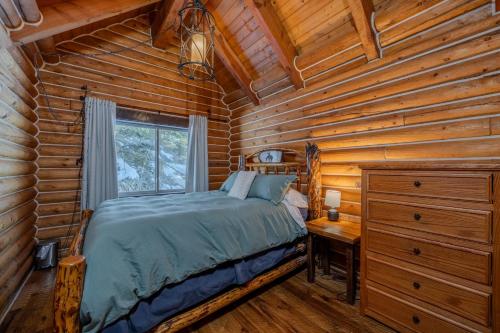 a bedroom with a bed in a log cabin at 20 mins to YNP-Cabin-Pet friendly in Island Park