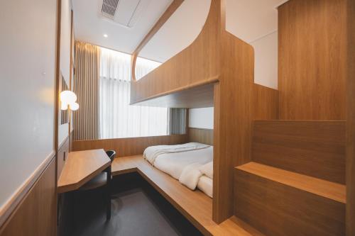 a small bedroom with a bed and wooden walls at 아랑재 arangjae in Seoul