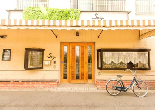 a bike parked in front of a building with a door at Osaka SENJU big Tatami house Max 16ppl direct to KIX airport in Osaka