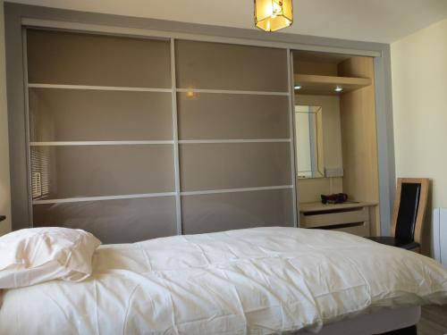 1 dormitorio con 1 cama blanca grande y espejo en Woodbury Court, en Bere Regis