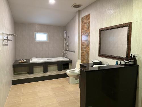 a bathroom with a tub and a toilet and a sink at Tsuya Hill Private Mountain View Villa, Chiang Rai in Mae Chan