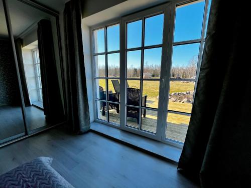 a room with a large window looking out at a field at Vahtralehe majutus in Tartu