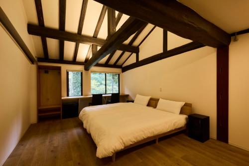a bedroom with a large bed in a room with wooden floors at YADO SEN -仙- Komatsu in Komatsu