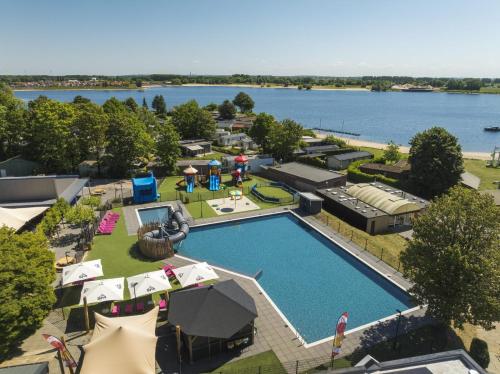 an overhead view of a resort with a pool and a lake at FerienChalet-Icra in Lathum