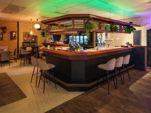 a bar in a restaurant with bar stools at FerienChalet-Icra in Lathum
