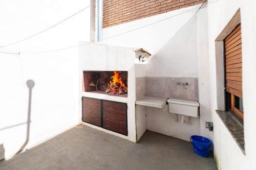 a fireplace in a white room with a fire place at Río Cuarto Host in Río Cuarto