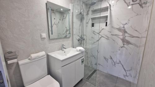a bathroom with a toilet and a sink and a shower at Ocean Breeze in Porto Moniz