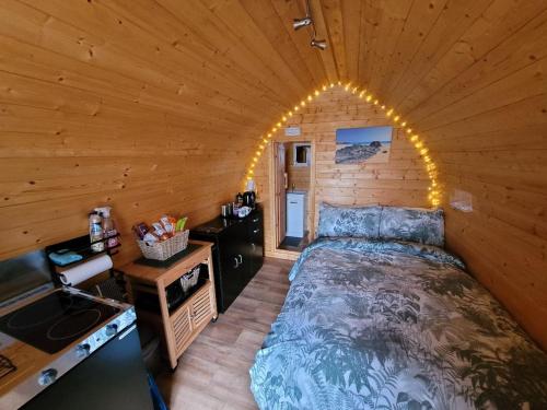 a bedroom in a log cabin with a bed at Ocean View Glamping Pod in Borve