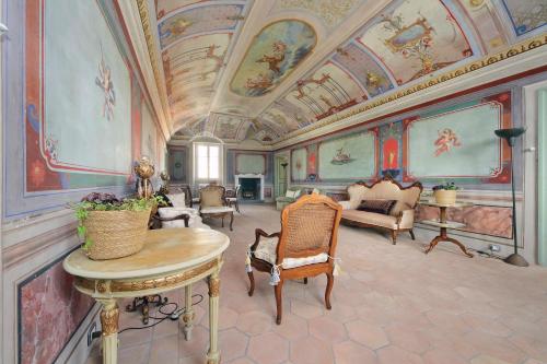 a living room with paintings on the ceilings and a table at Hotel Palazzo Vittoria Heritage Collection in Cerveteri