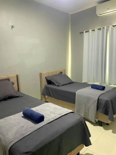 a bedroom with two beds with blue pillows on them at Dunas residence casa 15- Lençois Maranhense in Santo Amaro