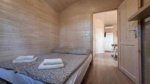 a small room with a bed with towels on it at LAZY DAYS domek nr 26 w Borsku in Borsk