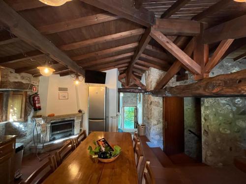 a kitchen and dining room with a table and a refrigerator at Cabaninhas House by Gerês Casas in Terras de Bouro