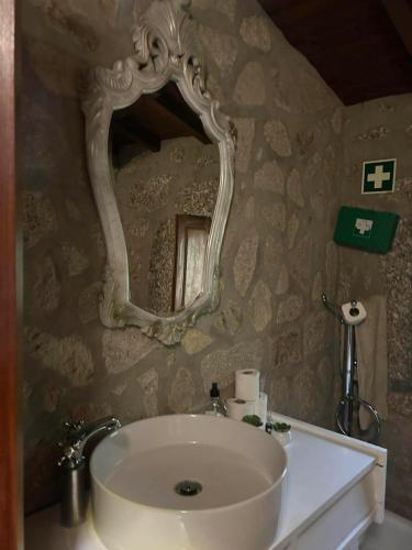 a bathroom with a sink and a mirror on the wall at Cabaninhas House by Gerês Casas in Terras de Bouro