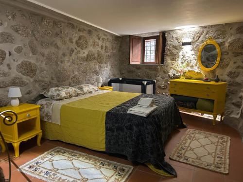 a bedroom with a bed with a yellow blanket and a mirror at Cabaninhas House by Gerês Casas in Terras de Bouro