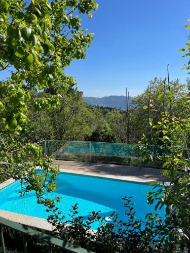 a swimming pool with a fence and trees at Cabaninhas House by Gerês Casas in Terras de Bouro